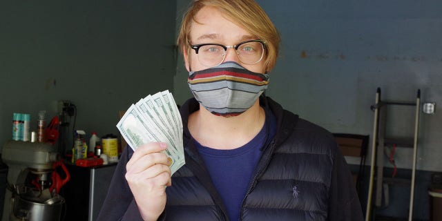 Andreas Flaten and his $1,000 (Courtesy of Coinstar)