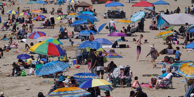 People enjoy the hot weather on Santa Monica Beach in Santa Monica, Calif., Wednesday, March 31, 2021. 