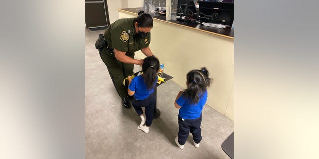 El Paso Border Patrol Sector Chief Gloria Chavez is giving girls, who were tossed from border wall, a snack inside the El Paso processing center.