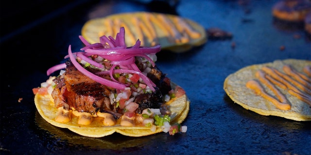 Tacos prepared by chef Mike Winneker appear at a makeshift kitchen outside of his home on April 3, 2021, in Scottsdale, Ariz. Beaten down by the pandemic, many laid-off or idle restaurant workers have pivoted to dishing out food with a taste of home. Some have found their entrepreneurial side, slinging their culinary creations from their own kitchens. (AP Photo/Ross D. Franklin)