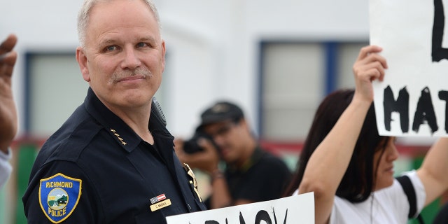 Le chef de la police de Richmond Chris Magnus se tient avec des manifestants pour protester contre la mort de Michael Brown et Eric Garner lors d'une manifestation pacifique à Richmond, en Californie, le 9 décembre 2014. 