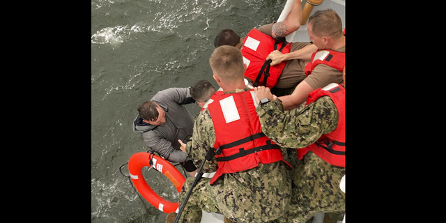 Crew members of the Coast Guard Cutter Glenn Harris pull a person from the water Tuesday after the Seacor Power capsized. (AP/US Coast Guard)