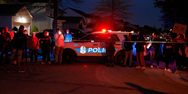 A crowd gathers to protest in the neighborhood where a Columbus police officer fatally shot a teenage girl, Tuesday, April 20, 2021, in Columbus, Ohio.