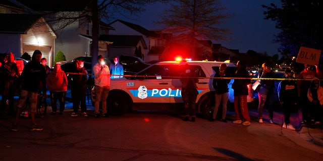 A crowd gathers to protest in the neighborhood where a Columbus police officer fatally shot a teenage girl, Tuesday, April 20, 2021, in Columbus, Ohio.