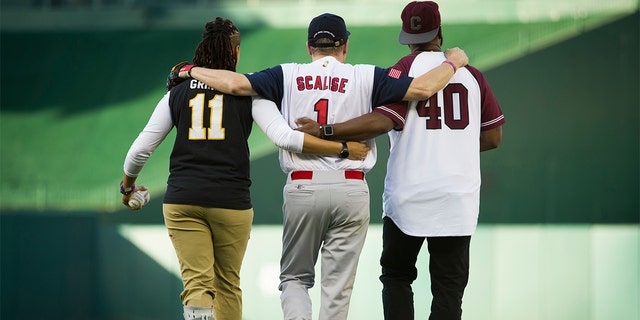 Capitol Police Special Agents Crystal Griner, left, and David Bailey, right, assist U.S. Rep. Steve Scalise to his position at second base at the start of the 57th Congressional Baseball Game at National's Park in Washington, Thursday, June 14, 2018.