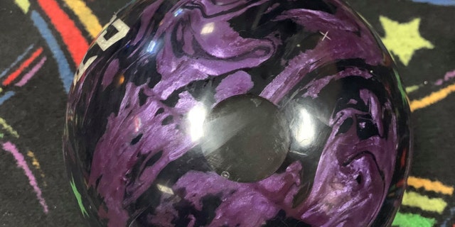 John Hinkle, Jr. filled the thumb hole of this bowling ball with his dad’s ashes.