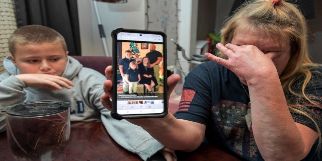 Darra Morales, right, shows a photo of her son Chaz Morales and his family on her phone, as Chaz Jr., 10, comforts his grandmother at their home in Slidell, La., on Wednesday, April 14, 2021. (AP/The Times-Picayune/The New Orleans Advocate)