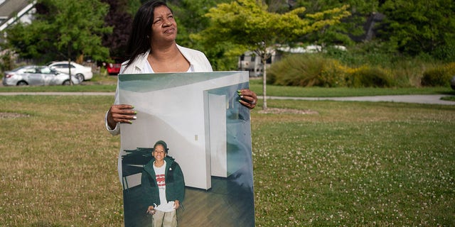 Donnitta Sinclair-Martin, mother of Horace Lorenzo Anderson, poses with a portrait of her son from about 10 years ago during a memorial and rally for peace in memory of Anderson on July 2, 2020 a Seattle.