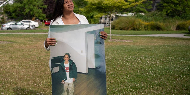 Donnitta Sinclair-Martin, mother of Horace Lorenzo Anderson, poses with a portrait of her son from about 10 years ago during a memorial and rally for peace in memory of Anderson on July 2, 2020 a Seattle.