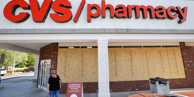 A shopper leaves a store with windows boarded up in anticipation of possible looting or vandalism following the killing of Andrew Brown Jr. by sheriffs last week, in Elizabeth City, North Carolina, U.S. April 27, 2021.