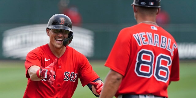 Boston Red Sox' Enrique Hernandez, left, reacts as he rounds the bases and runs towards third base coach Will Venable after hitting a home run in the third inning of Inning of a spring training baseball game against the Atlanta Braves on Monday, March 29, 2021, in North Port, Fla. (AP Photo/John Bazemore)