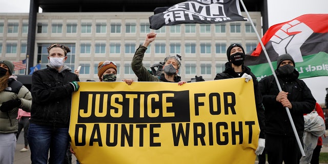 Demonstrators hold a banner in front of the FBI Minneapolis Division building as they march days after Daunte Wright, 20, was shot and killed by former Brooklyn Center Police Officer Kim Potter, in Brooklyn Center, Minnesota, U.S., April 13, 2021.