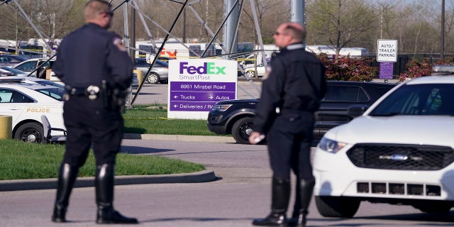Police stand near the scene in Indianapolis where multiple people were shot at a FedEx Ground facility. (AP)