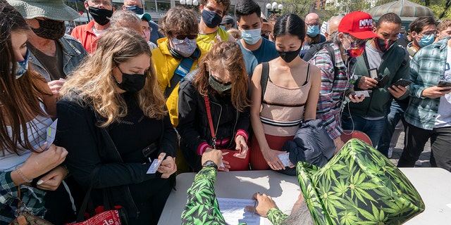 A man wearing a cannabis costume hands out marijuana cigarettes in New York during a "Joints for Jabs" event, where adults who showed their COVID-19 vaccination cards received a free joint. (AP Photo/Mark Lennihan, File)