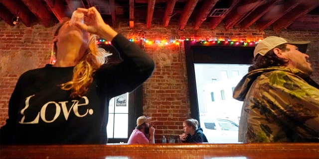 In this Tuesday, April 13, 2021 file photo, Allison Richter drinks her free shot at the bar, after receiving the Moderna COVID-19 vaccine, during a vaccine event. (AP Photo/Gerald Herbert)