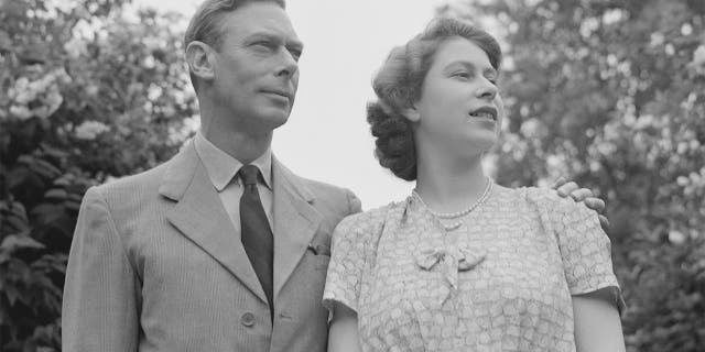 La princesa Isabel con su padre, el rey Jorge VI, en los jardines del Castillo de Windsor, Inglaterra, el 8 de julio de 1946. 