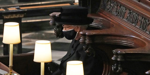 Queen Elizabeth II looks at how pallet bearers carry the coffin of Prince Philip, Duke of Edinburgh into St. George's Chapel of the Pallbearers at the Funeral of Prince Philip, Duke of Edinburgh at Windsor Castle on 17 April 2021 in Windsor, UK.