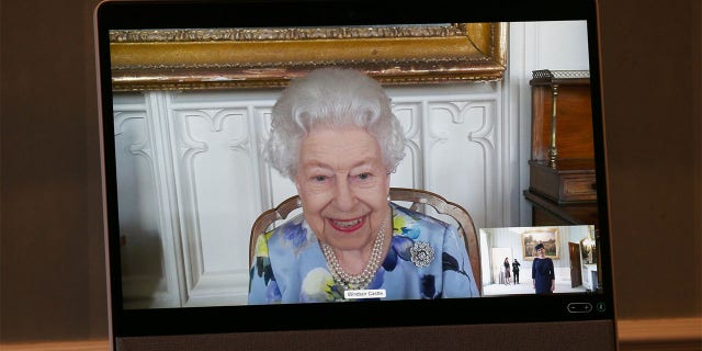 Queen Elizabeth II appears on a screen by videolink from Windsor Castle, where she is in residence, during a virtual audience to receive Her Excellency Ivita Burmistre, the Ambassador of Latvia at Buckingham Palace on April 27, 2021, in London, England.