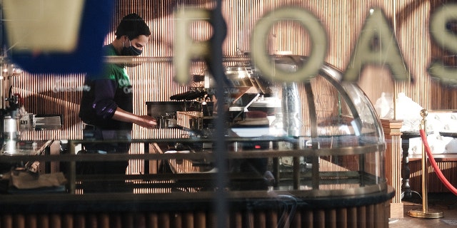 A man works in a coffee shop in  a Manhattan neighborhood on Feb. 5, 2021, in New York City. (Photo by Spencer Platt/Getty Images)