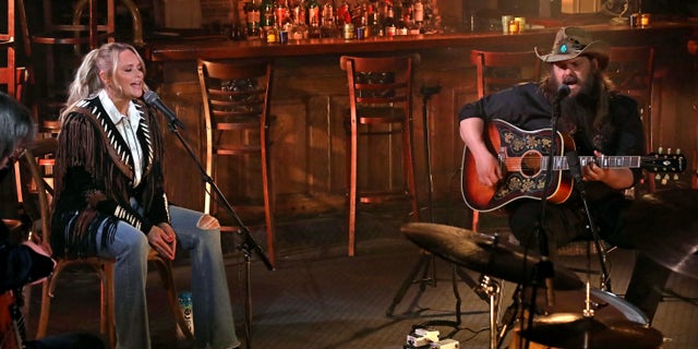 Seated in a Nashville-area bar, Miranda Lambert. left, looked right at home while performing with Chris Stapleton, right, in a black fringe jacket affixed over a white collared shirt. (Photo by Terry Wyatt/ACMA2021/Getty Images for ACM)