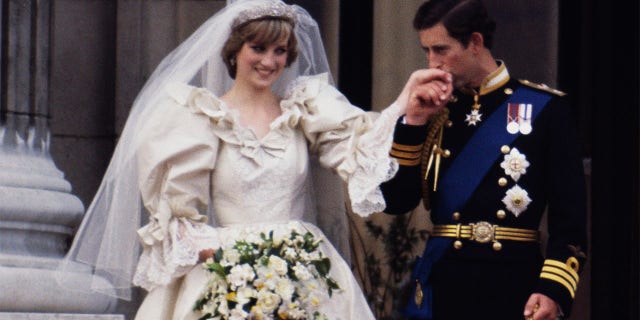 The Prince and Princess of Wales on the balcony of Buckingham Palace on their wedding day, 29th July 1981. Diana wears a wedding dress by David and Elizabeth Emmanuel and the Spencer family tiara.