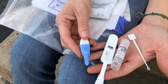 March 9, 2021: In this file photo, the organizer of the solution-oriented addiction response, Brooke Parker, displays an HIV test kit in Charleston, W.Va. 
