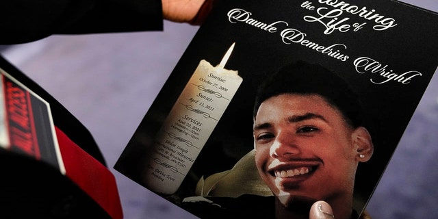 The program for the funeral services of Daunte Wright is held by a mourner at Shiloh Temple International Ministries in Minneapolis, Thursday, April 22, 2021. Wright, 20, was fatally shot by a Brooklyn Center, Minn., police officer during a traffic stop. (AP Photo/John Minchillo, Pool) 