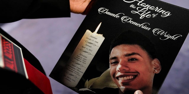 The program for the funeral services of Daunte Wright is held by a mourner at Shiloh Temple International Ministries in Minneapolis, Thursday, April 22, 2021. Wright, 20, was fatally shot by a Brooklyn Center, Minn., police officer during a traffic stop. (AP Photo/John Minchillo, Pool)