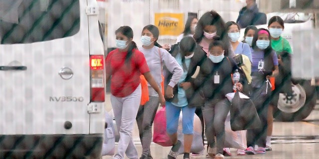 Teenage migrant girls are loaded into vans to be transported out of the National Association of Christian Churches facility, on Saturday, April 17, 2021, in Houston. (Godofredo A. Vásquez/Houston Chronicle via AP)