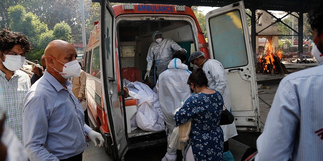 April 19, 2021: Health workers prepare to take out bodies of six victims of COVID-19 from an ambulance for cremation in New Delhi, India.