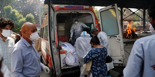 April 19, 2021: Health workers prepare to take out bodies of six victims of COVID-19 from an ambulance for cremation in New Delhi, India.