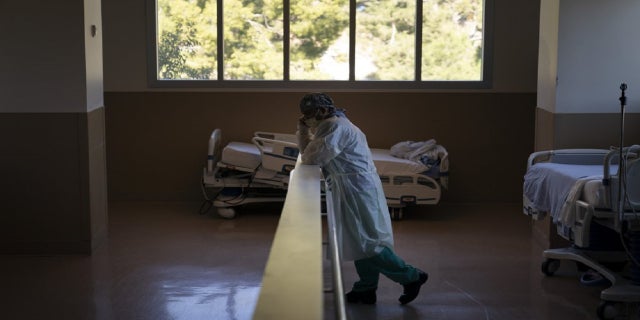 In this Nov. 19, 2020, file photo, respiratory therapist Babu Paramban talks on the phone next to hospital beds while taking a break in the COVID-19 unit at Providence Holy Cross Medical Center in the Mission Hills section of Los Angeles. (AP Photo/Jae C. Hong, File)