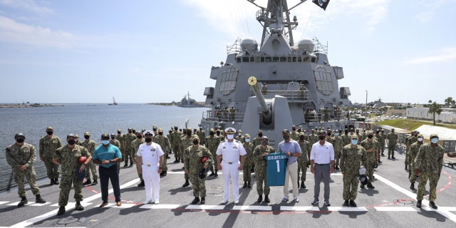 Meyer, Strong and Baalke pose for a photo with the sailors.
