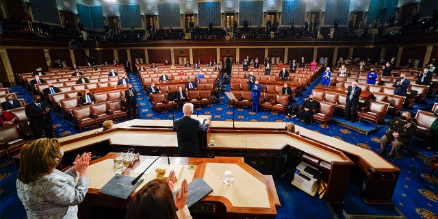 President Biden addresses a joint session of Congress, 水曜日, 4月 28, 2021, in the House Chamber at the U.S. Capitol in Washington, as Vice President Kamala Harris and House Speaker Nancy Pelosi of Calif., stand and applaud. (Melina Mara/The Washington Post via AP, プール)