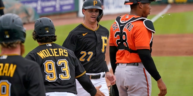 Pittsburgh Pirates' Kevin Newman (27) and Tony Wolters (93) score behind Baltimore Orioles catcher Pedro Severino (28) on a double by teammate Phillip Evans during the third inning of a spring training exhibition baseball game in Bradenton, Fla., Monday, March 22, 2021. (AP Photo/Gene J. Puskar)