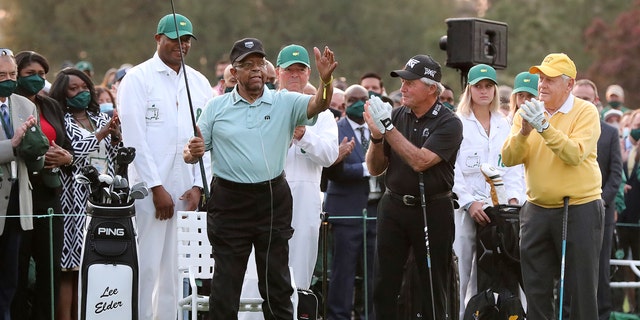 Honorary starter Lee Elder, left, gestures as he is introduced and applauded by honorary starters Gary Player and Jack Nicklaus, right, before the ceremonial tee shots to begin the Masters golf tournament at Augusta National Golf Club in Augusta, Ga., April 8, 2021.