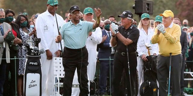 Honorary starter Lee Elder, left, gestures as he is introduced and applauded by honorary starters Gary Player and Jack Nicklaus, right, before the ceremonial tee shots to begin the Masters golf tournament at Augusta National Golf Club in Augusta, Ga., Thursday, April 8, 2021.