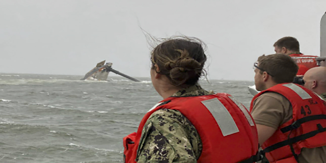 Coast Guard members scan the water Tuesday while searching for those missing after the Seacor Power, a 129-foot-ship, overturned near Louisiana. (AP/U.S. Coast Guard)