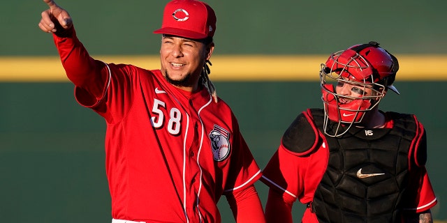 Cincinnati Reds starting pitcher Luis Castillo (58) walks to the dugout with catcher Tucker Barnhart after warming up in the bullpen prior to the team's spring training baseball game against the Chicago Cubs on Saturday, March 27, 2021, in Goodyear, Ariz. (AP Photo/Ross D. Franklin)
