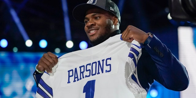 Penn State linebacker Micah Parsons holds a team jersey after the was chosen by the Dallas Cowboys with the 12th pick in the NFL football draft Thursday, April 29, 2021, in Cleveland. (AP Photo/Tony Dejak)