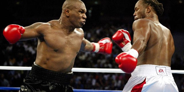 Mike Tyson (L) and Lennox Lewis trade punches during round one of their WBC/IBF/IBO World Heavyweight Championship bout at the Pyramid Arena in Memphis, Tennessee, June 8, 2002.
