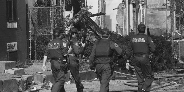 Several Philadelphia police officers patrol the West Philadelphia neighborhood destroyed by the bombing of the MOVE headquarters in 1985.