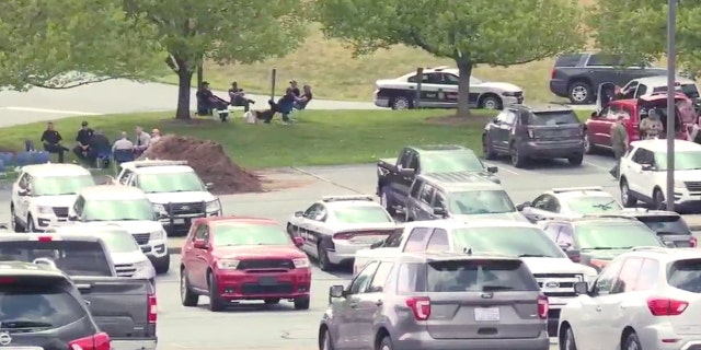 Police set up a staging area at the Mount Vernon Baptist Church, which is also the site of a school that was placed on lockdown amid an ongoing standoff at a nearby home.