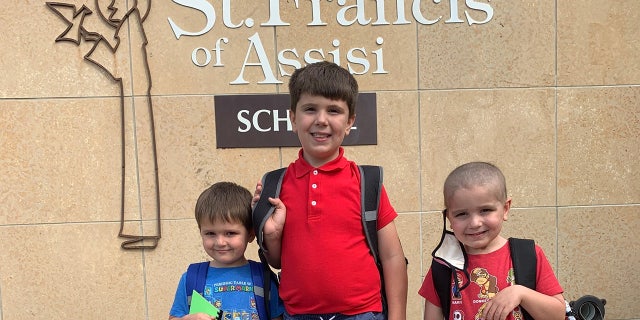 Nathan Herber, his twin bother Justin, and older brother Grant at St. Francis of Assisi in Rochester, Minnesota.