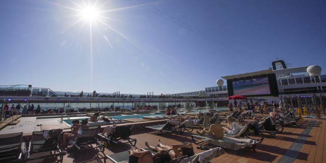 Guests lounge near a pool on the MSC Grandiosa as the rest of Italy is heading back into full lockdown over the Easter weekend, with shops closed and restaurants and bars open for takeout only to try to minimize holiday outbreaks. (AP Photo/Andrew Medichini)