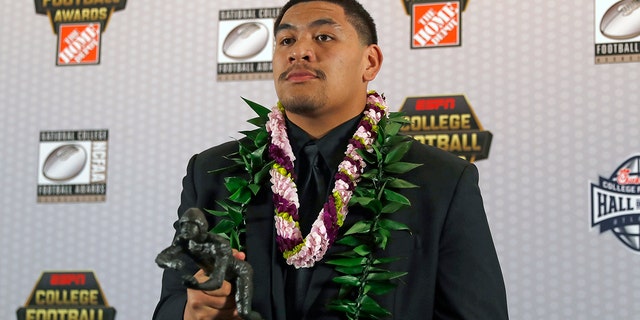 FILE - In this Dec. 12, 2019, file photo, Oregon's Penei Sewell poses with Outland Trophy for being the nation's best interior lineman, in Atlanta. Sewell is a likely first-round pick in the NFL Draft, April 29-May 1, 2021, in Cleveland.(AP Photo/John Bazemore, File)