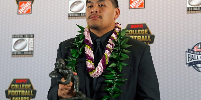 FILE - In this Dec. 12, 2019, file photo, Oregon's Penei Sewell poses with Outland Trophy for being the nation's best interior lineman, in Atlanta. Sewell is a likely first-round pick in the NFL Draft, April 29-May 1, 2021, in Cleveland.(AP Photo/John Bazemore, File)