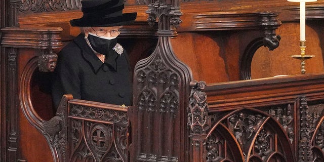 Britain's Queen Elizabeth II looks on as she sits alone in St. George’s Chapel during the funeral of Prince Philip.