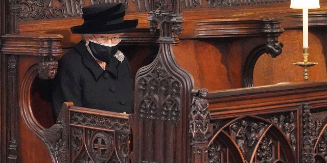 Britain's Queen Elizabeth II looks on as she sits alone in St. George’s Chapel during the funeral of Prince Philip.