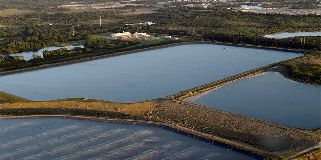 This photo shows a reservoir near the old Piney Point phosphate mine, Saturday, April 3, 2021 in Bradenton, Fla. Florida Gov. Ron DeSantis declared a state of emergency Saturday after a significant leak at a large pond of wastewater threatened to flood roads and burst a system that stores polluted waters. The pond where the leak was discovered is at the old Piney Point phosphate mine, sitting in a stack of phosphogypsum, a waste product from manufacturing fertilizer that is radioactive. (Tiffany Tompkins/The Bradenton Herald via AP)